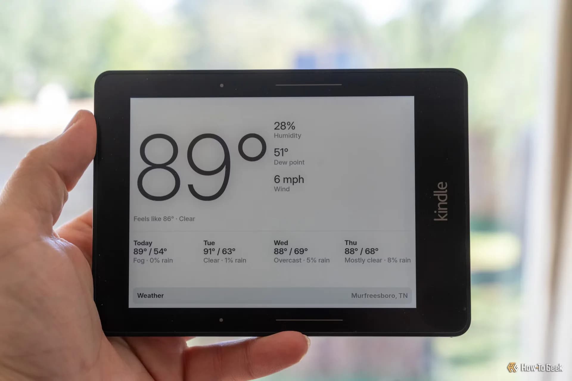An Amazon Kindle e-reader propped up displaying text and diagrams on an e-ink screen.