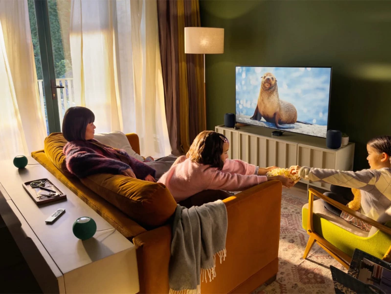 The Apple TV 4K set-top box resting on a media console next to a Siri Remote