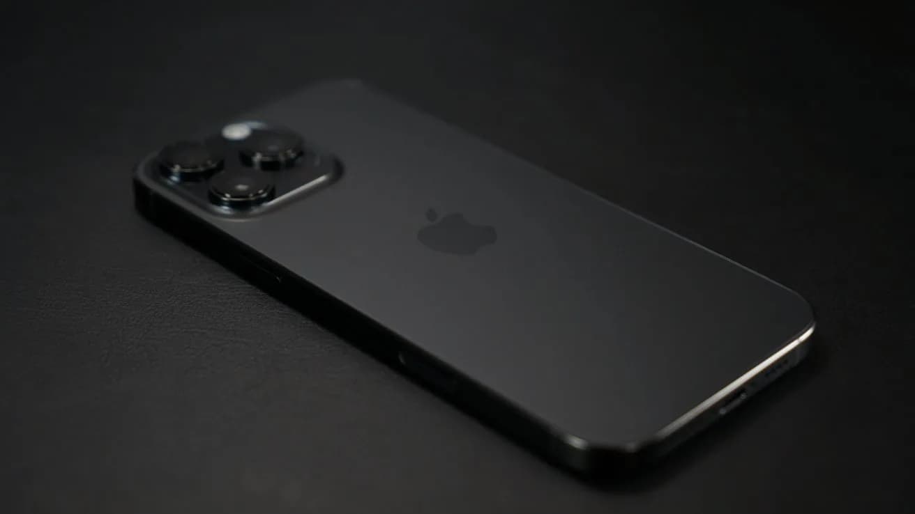 The fourth-generation Siri Remote resting beside an Apple TV set-top box on a wooden tabletop.