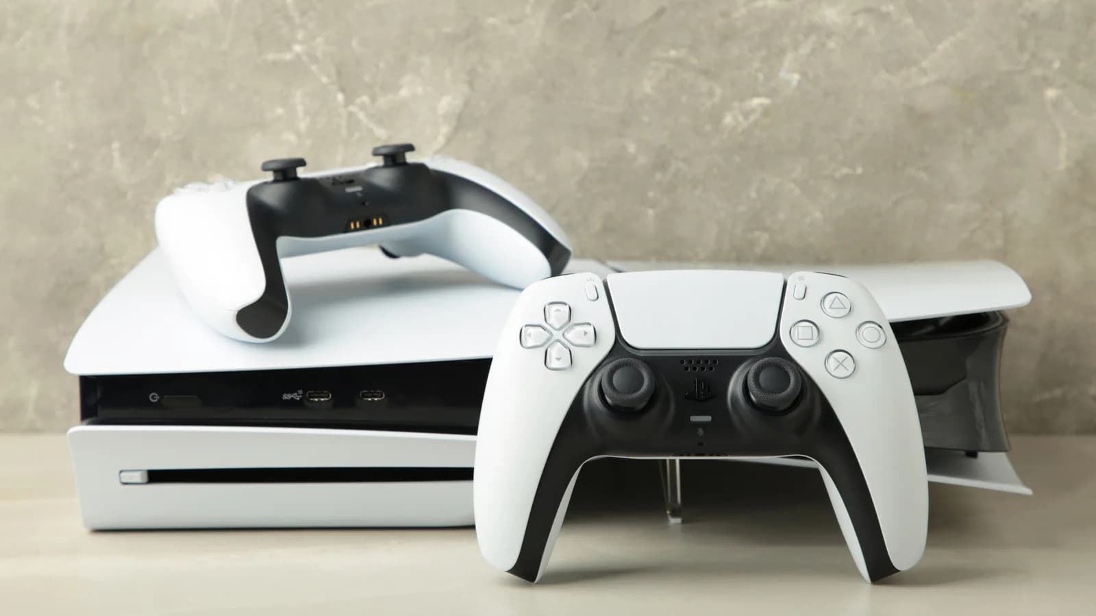 A PlayStation 5 Pro console standing upright next to a DualSense controller and assorted accessories