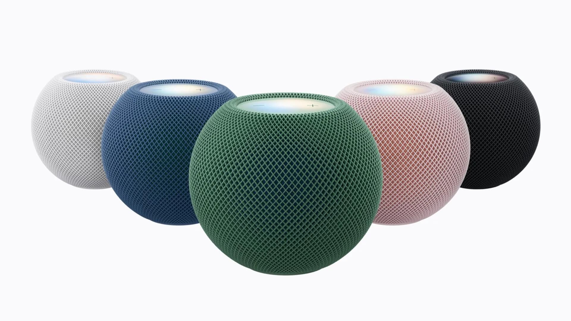 Apple HomePod mini 2 smart speaker sitting on a table showing illuminated top panel