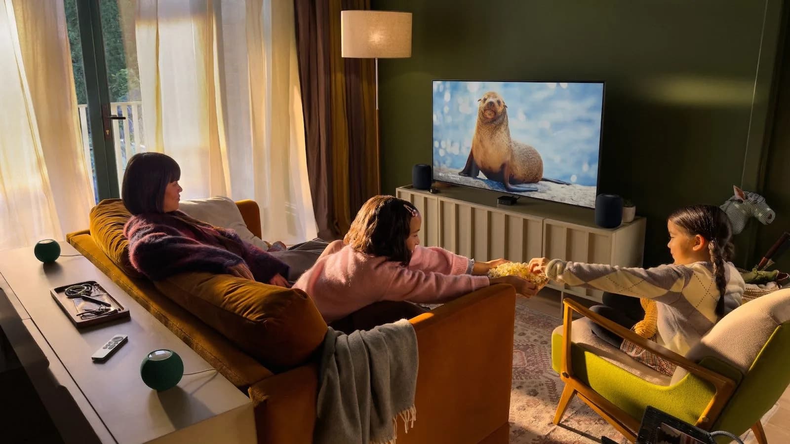 Apple TV 4K streamer alongside HomePod and HomePod Mini speakers arranged for a home cinema setup