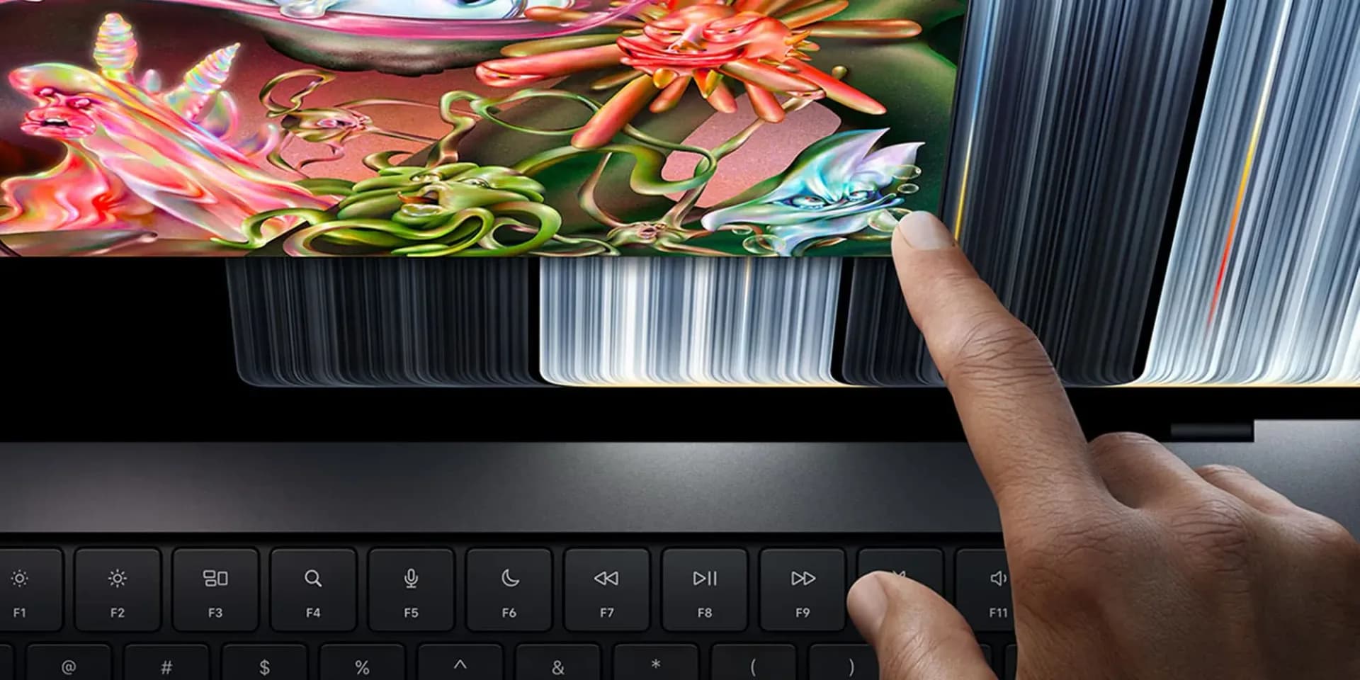 Apple MacBook Pro laptop with OLED display open on a desk
