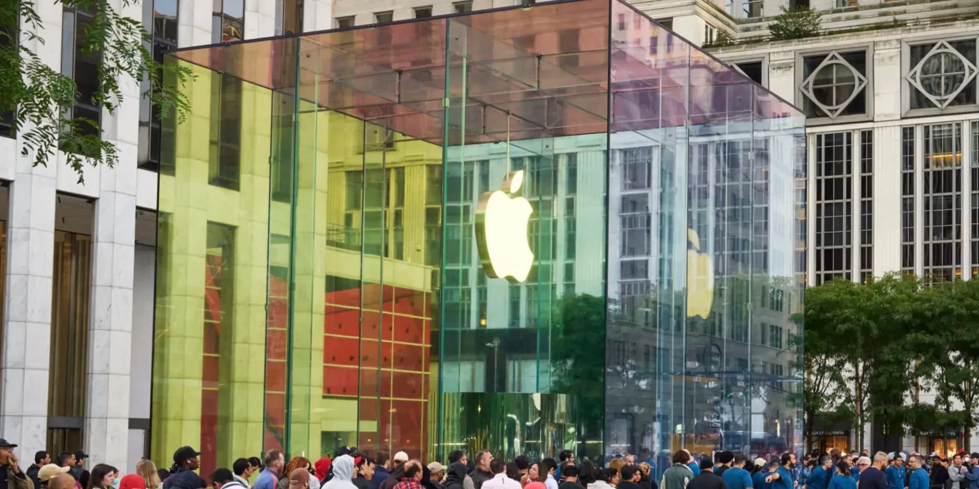 Large rectangular structures wrapped in black cloth and white plastic set up outside Apple's Fifth Avenue glass cube store entrance.